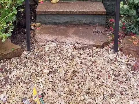 Two slim grey handrails either side of stone garden steps leading up to a lawn
